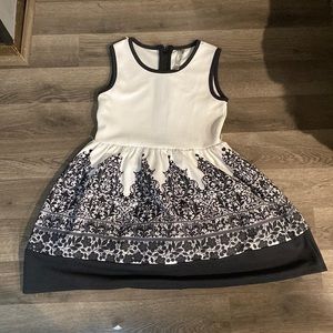 Black and white dress with black patterns on the bottom of the dress